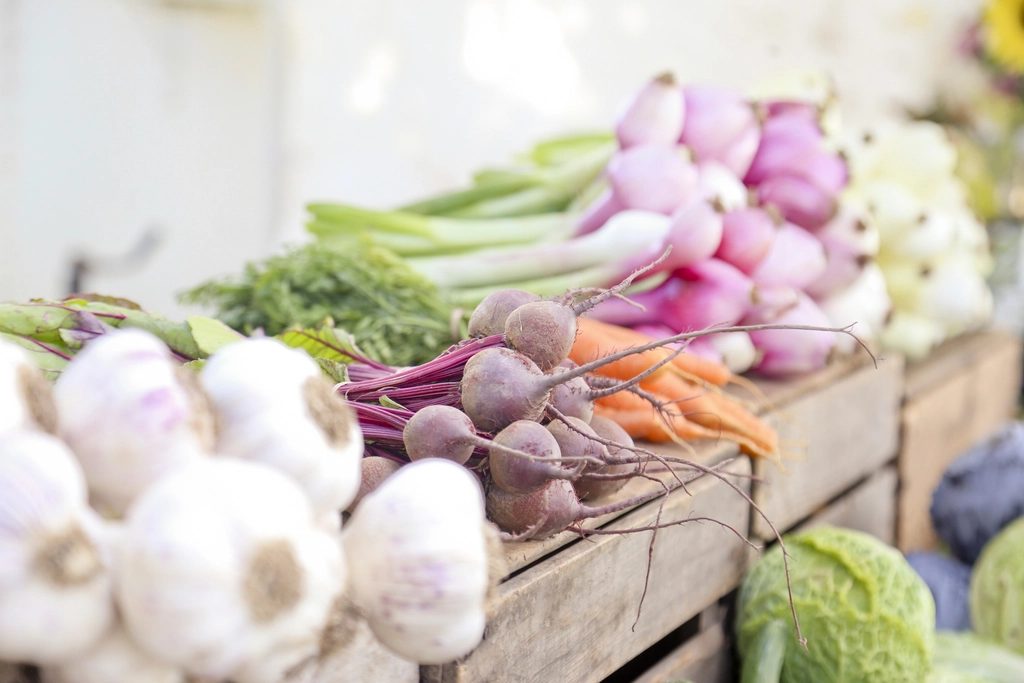Farmers market stall with crates of fresh vegetables displayed for sale