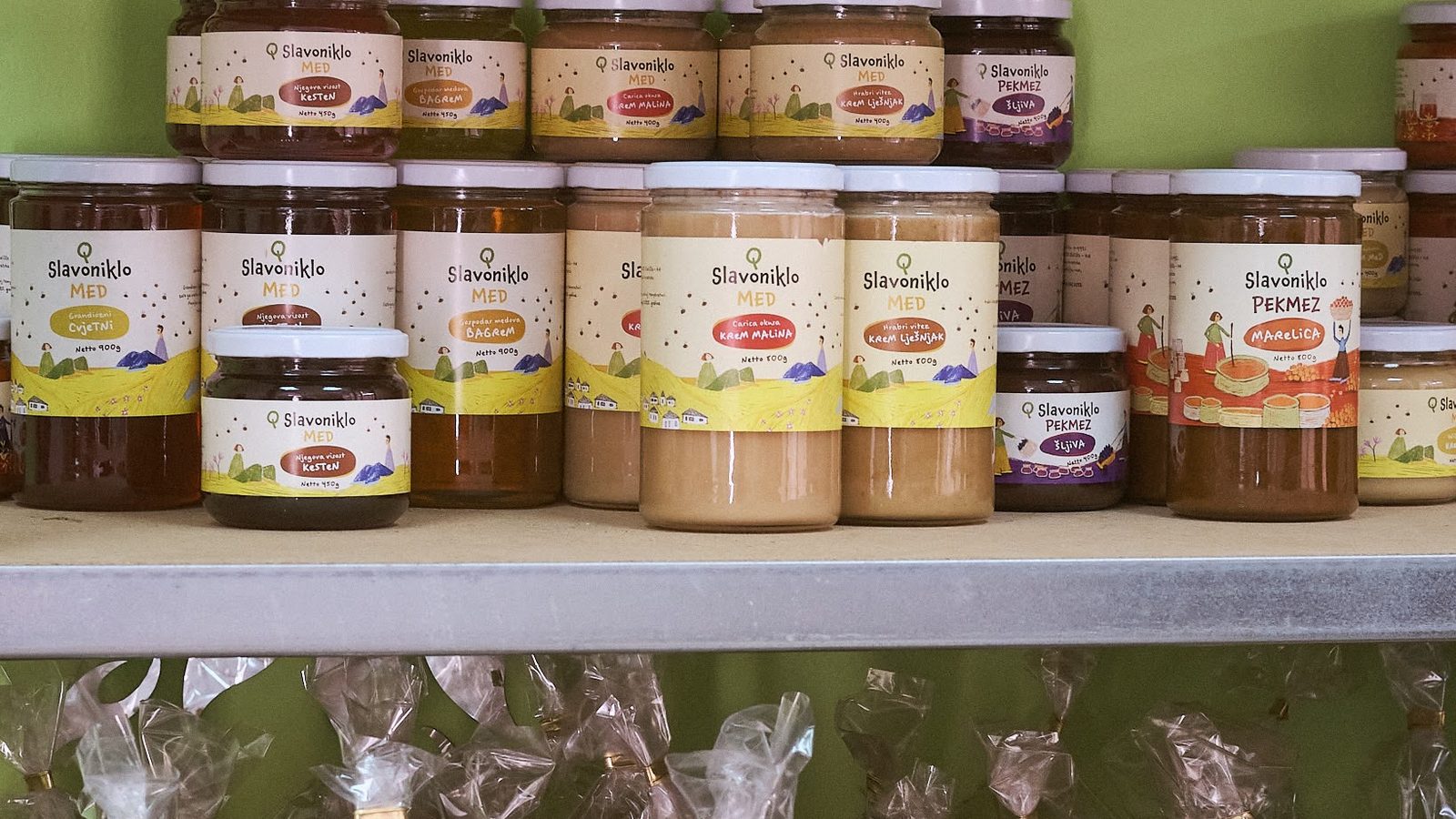 Shelves stocked with jars of honey and preserves from local producers.