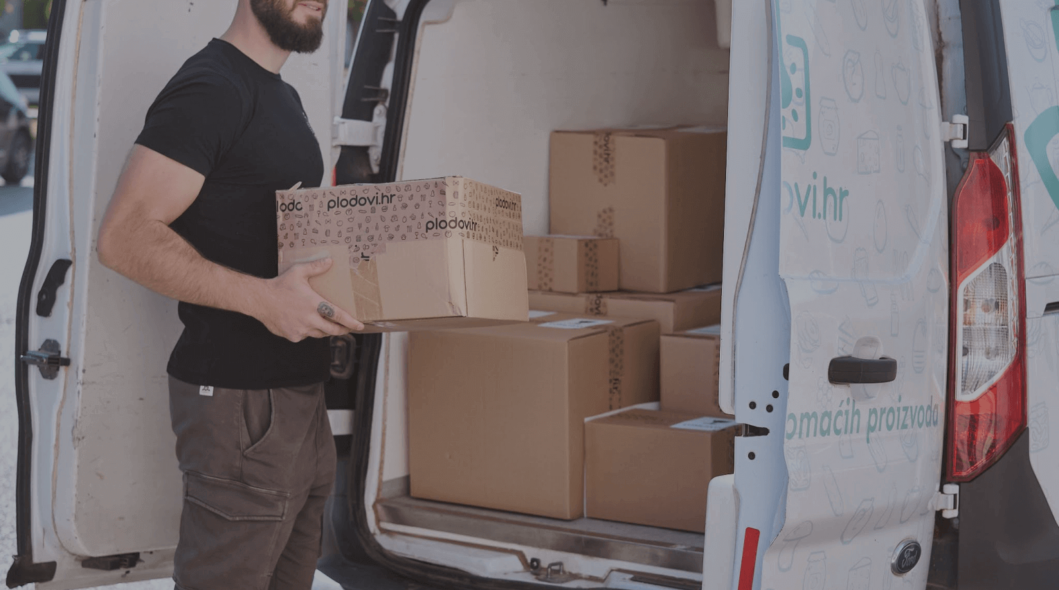 A driver loading Plodovi.hr boxes into a delivery van